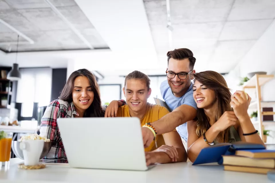 Group of young people enjoying group study at table.